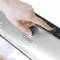 A hand is pressing the touch surface of a silver vacuum sealing device by Caso Design to seal a food package.