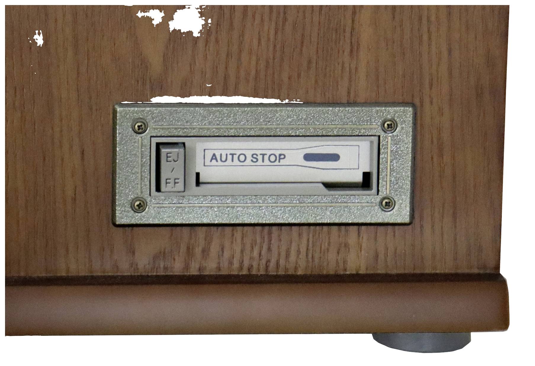 A wooden box contains a display plate with a switch. The switch has two positions: 'EJ' and 'FF'. Between them is written 'AUTO STOP'.
