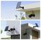 A modern security camera mounted on a building, powered by a solar panel. The setup is shown from different angles against a clear sky.