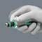 A hand is holding a medical device with a green twist-off cap. It demonstrates how the device is rotated to seal it.