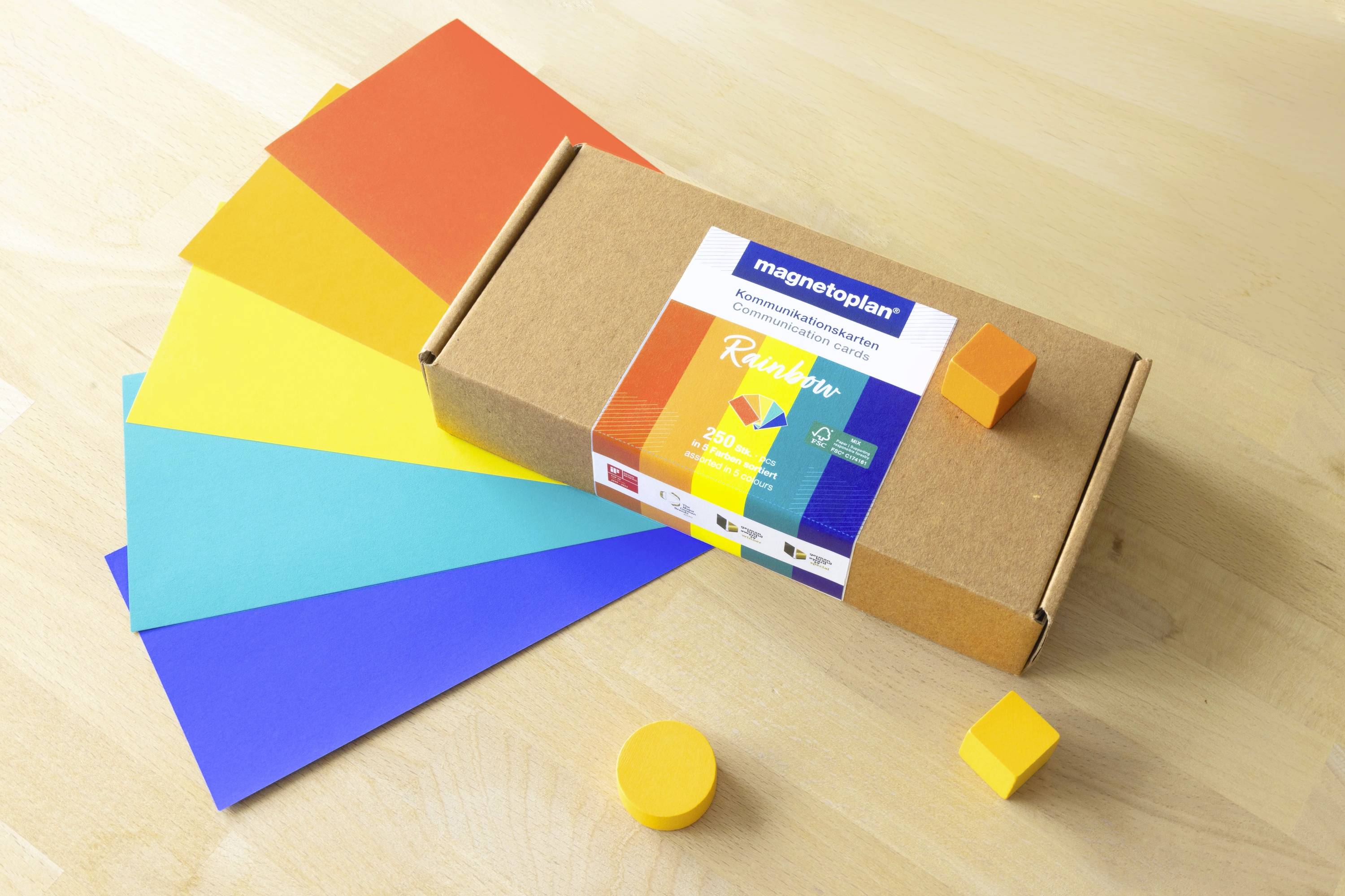 A box of Magnetplan cubes lies on a table, surrounded by colourful rectangular cards in blue, turquoise, yellow, orange and red.