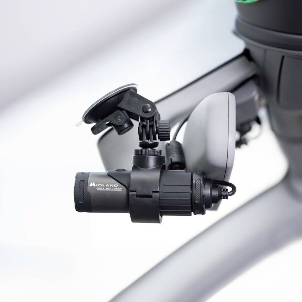 A black camera is attached to a grey suction cup that is mounted on a smooth surface.