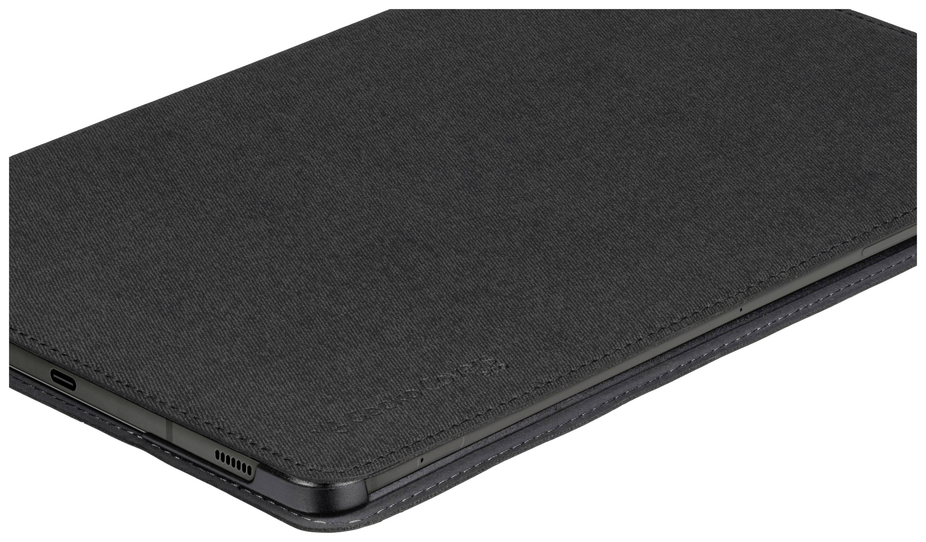 Dark tablet in a black fabric protective case, lying on a flat surface. Connections and speakers are visible on the underside.