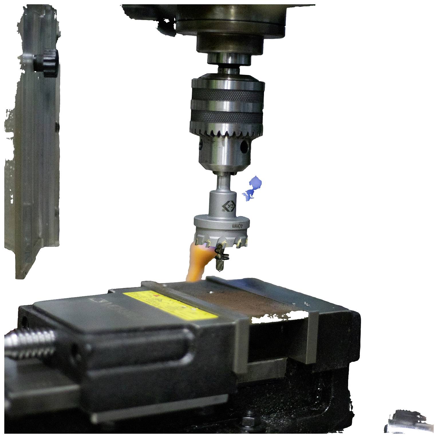 'Industrial drilling machine processing a metal plate, secured in a vice, in a workshop environment.'