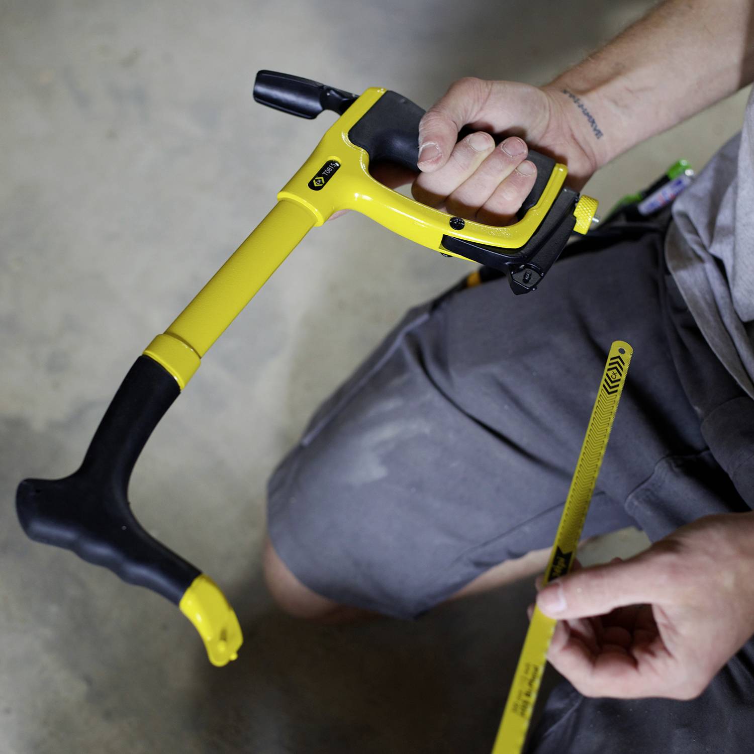 A person is holding a yellow tape measure, which is used for measuring distances. The hands and the tape measure are visible in the image.