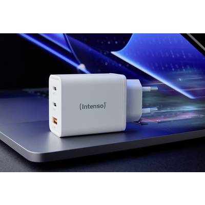 A white charger with the inscription 'Intenso' is resting on a laptop. It has two USB-C and one USB-A ports.