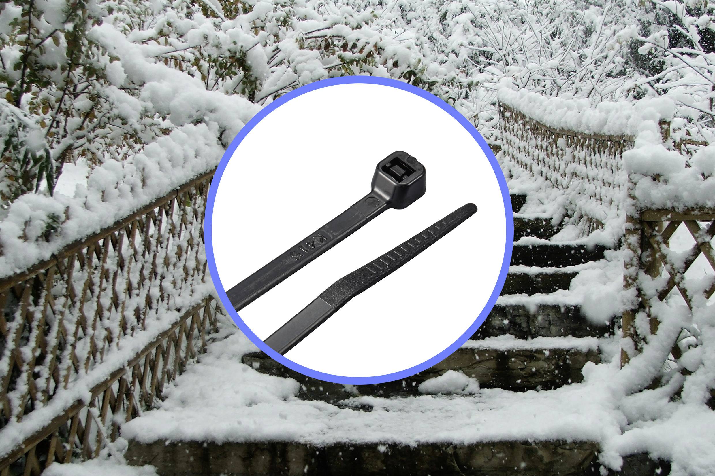 Cable ties in the foreground with a snow-covered staircase and handrail in the background.