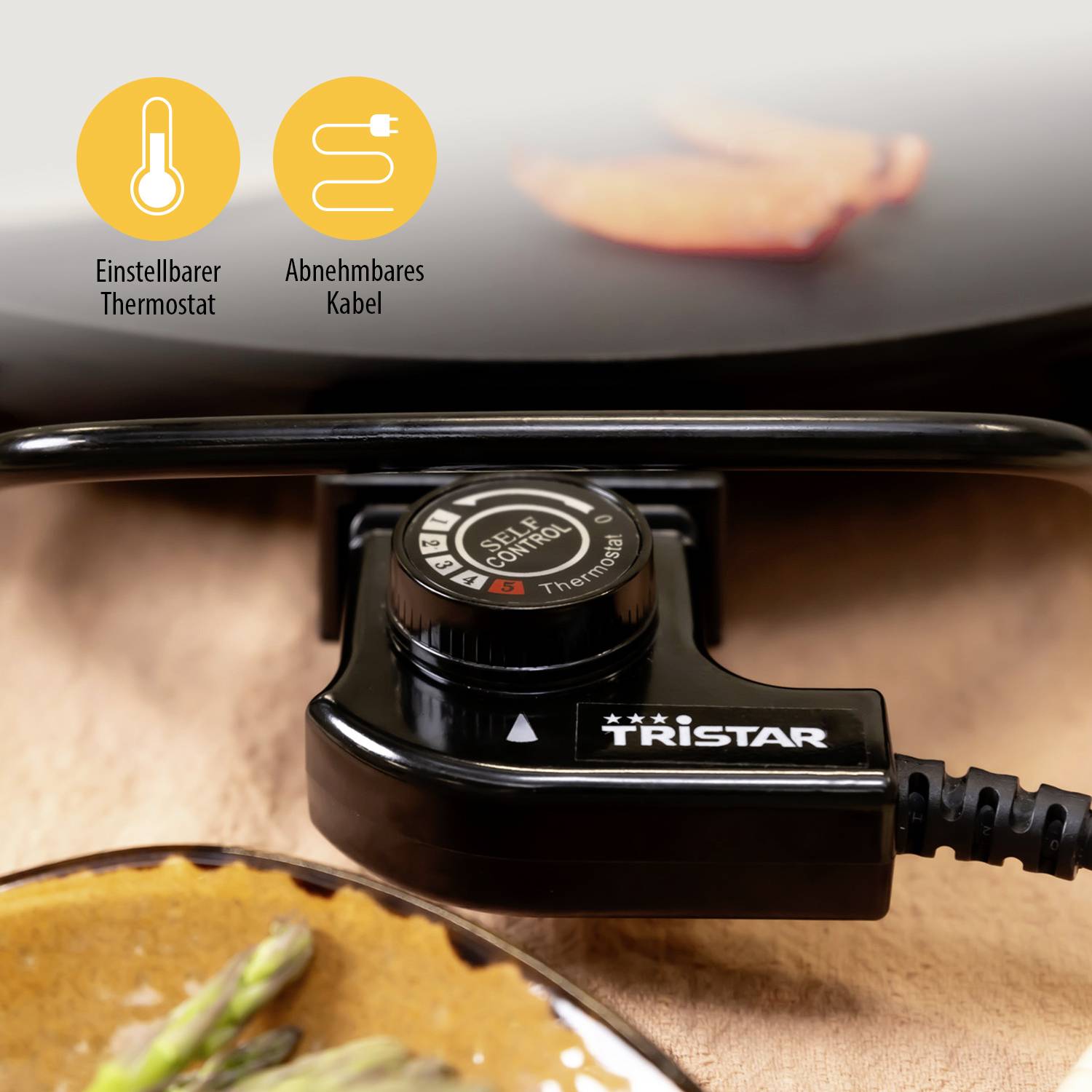 Close-up of an electric barbecue with an adjustable thermostat and detachable cable. A piece of meat is being grilled.