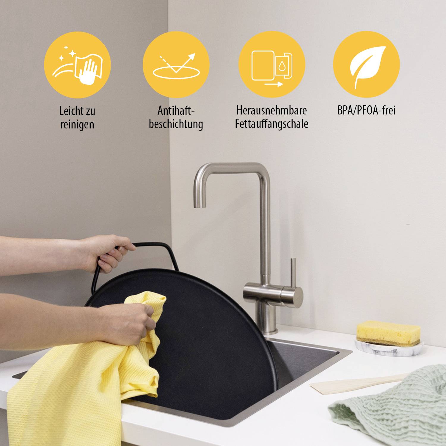 A person is cleaning a large, round cooking appliance. Above it are four symbols: 'Easy to clean', 'Non-stick coating', 'Removable fat collection tray', 'BPA/PFOA free'.