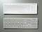Two white keyboards on a grey background; the upper one with keys labelled in black, the lower one plain without any markings.