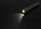 Black torch illuminates on black background, light beam pointing to the left.