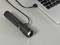 A torch is connected to a laptop via a USB cable. It appears to be lying close to the keyboard.