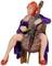 A miniature sculpture of a seated cellist in a purple dress, with red hair, playing the cello. Artistic representation of a musical instrument.