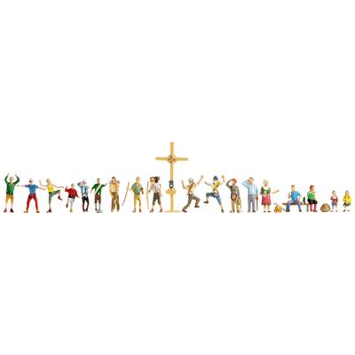 Numerous people engaging in various leisure activities gather around a large wooden summit cross in the mountains.