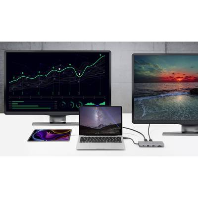 A laptop is connected between two larger monitors on a desk. The left monitor displays a diagram, the right monitor shows a sunset over the sea.