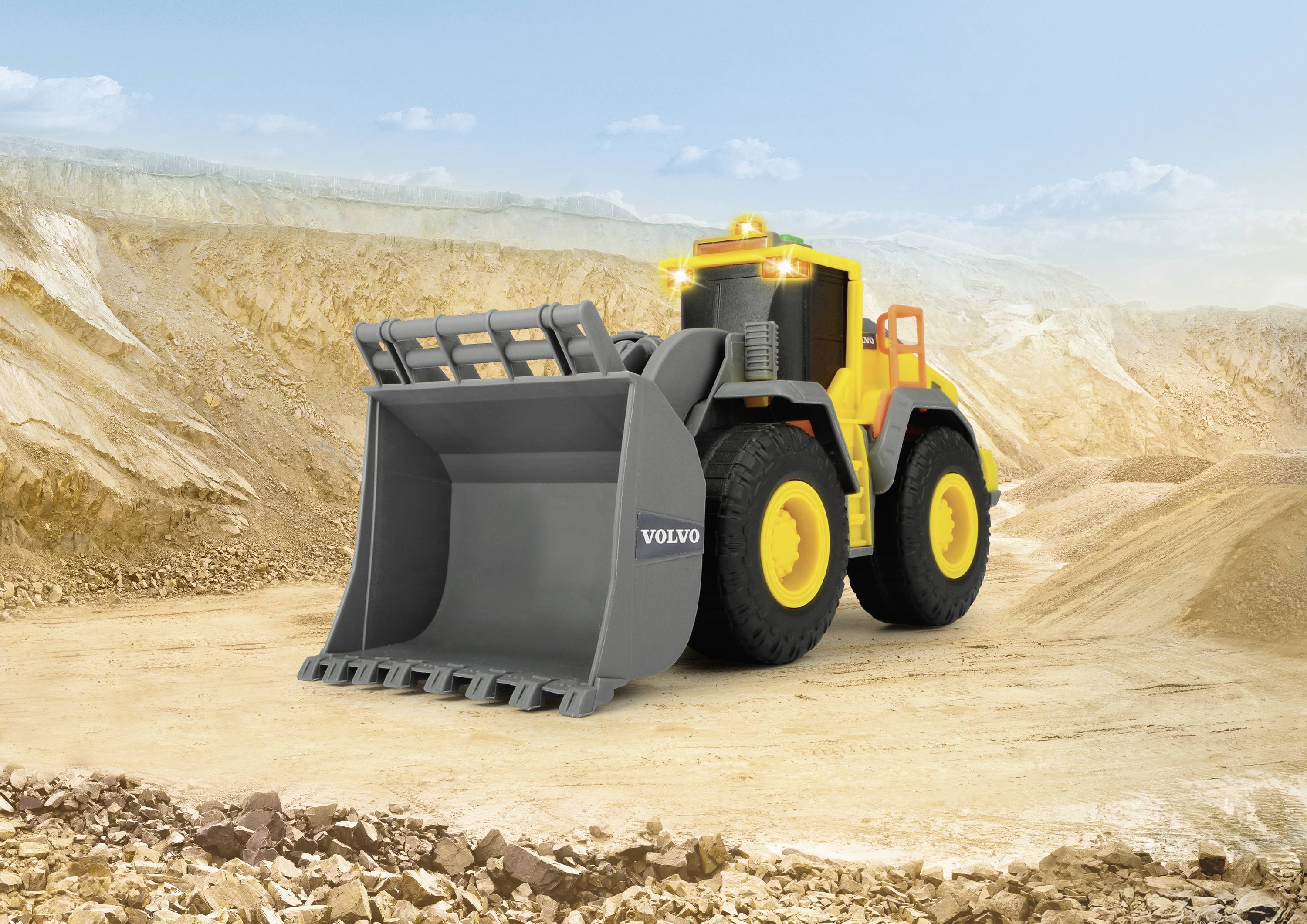 Yellow wheeled loader with a large bucket attachment stands in a vast, sandy landscape with a blue sky in the background.