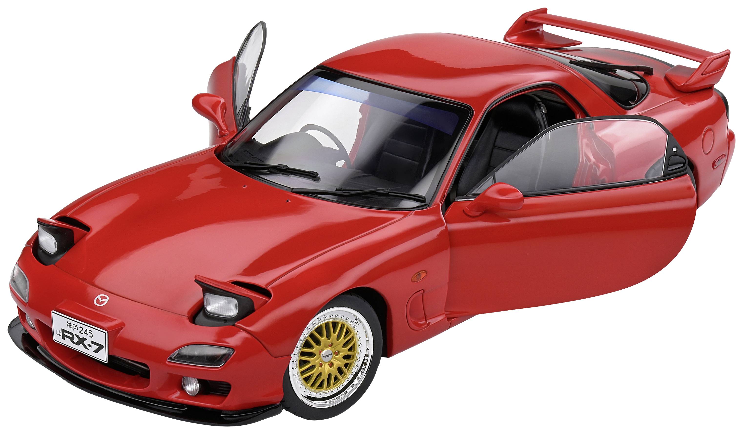 A red car with open doors and golden alloy wheels is sitting on a table. The vehicle has a sporty design.