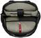 An opened black rucksack reveals a large grey main compartment with padded inserts and a red strap for securing items.
