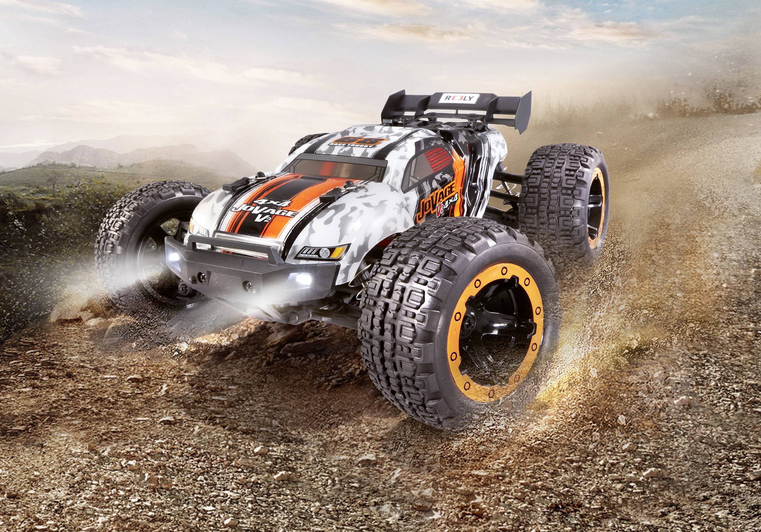 A remote-controlled car speeds along a dusty path. It is sturdy with large tyres and a sporty design.