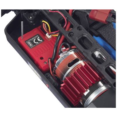 A red electric motor with cooling fins in a remote-controlled car, surrounded by cables and a control device, visible internally.