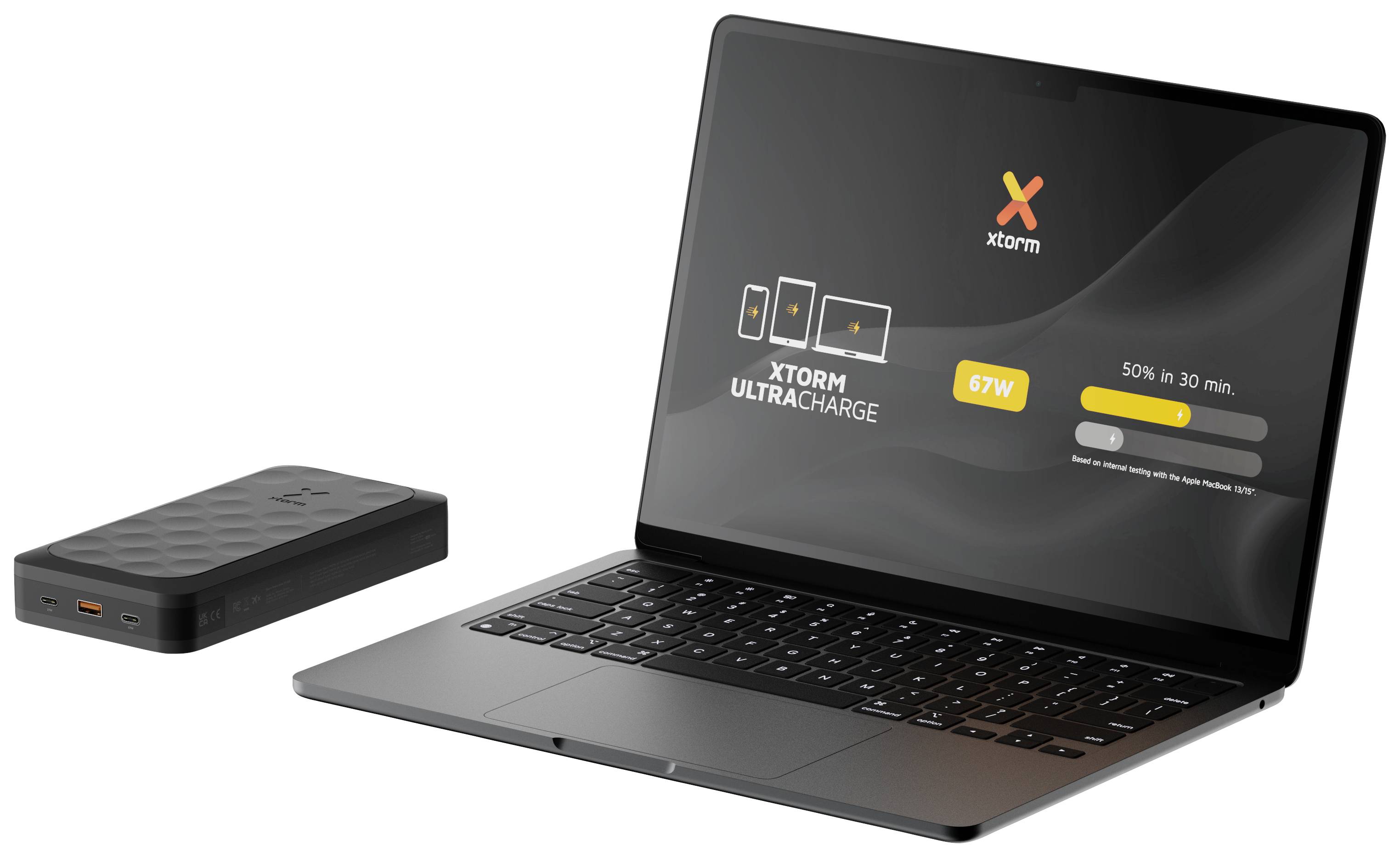 'Xtorm' Powerbank charges laptop with 67W. Screen displays charging progress: 50% in 30 mins. Product image in modern setting.