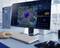 A hand taps on a keyboard in front of a monitor displaying virological data and a 3D representation of a virus in a laboratory setting.
