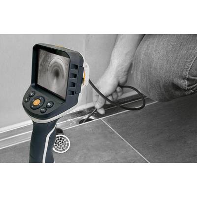 A person is examining a drain using an inspection camera. The camera's image shows the interior of the pipe.