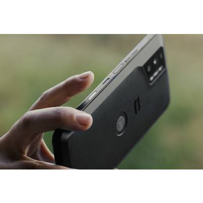 A hand is holding a smartphone nearby, with the screen not visible. The focus is on the control buttons and the camera.