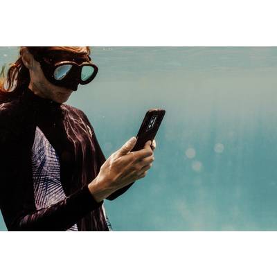 A person is wearing a diving mask and using a smartphone underwater. The environment is blue-green, suggesting a sea or swimming pool.