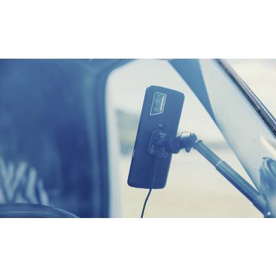 Smartphone mounted on a holder in a car, connected to a charging cable and ready for navigation or hands-free calls while driving.