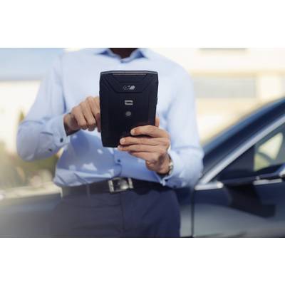 A man in business attire is using a tablet outdoors. A car is visible in the background, suggesting mobility or technology.