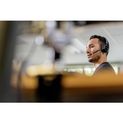 A man wearing a headset is working in an office, possibly as a customer service representative or in technical support.