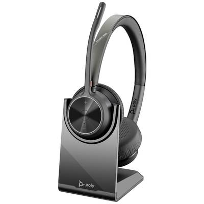 Wireless headset on charging dock, with microphone boom and volume control, brand 'Poly'. Perfect for calls and meetings.