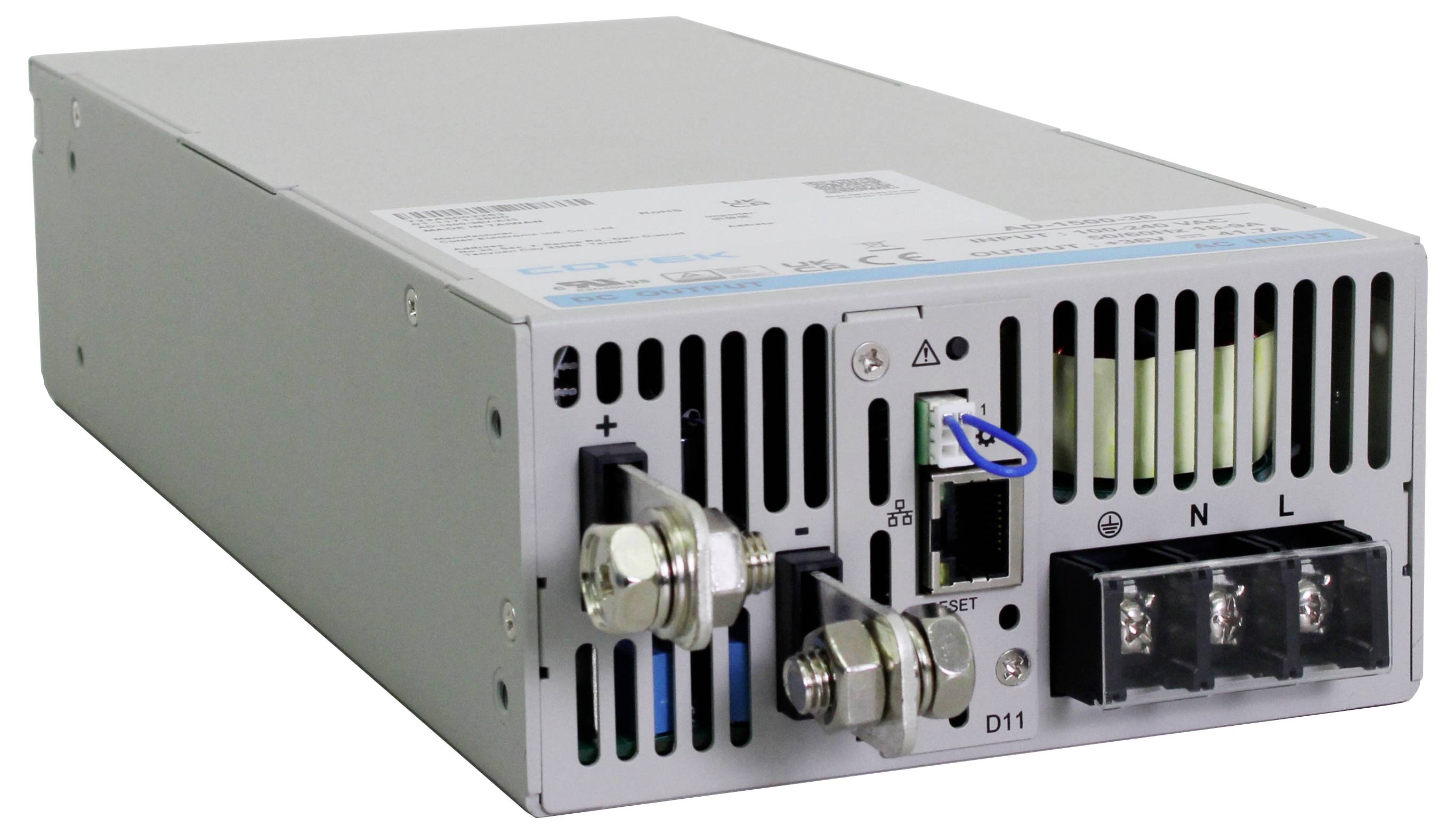 A grey electronic device with ventilation slots, screw terminals for positive and negative poles, and a mains cable connection.