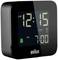 A digital alarm clock displays '12:15 AM' and '7:00 AM' as alarm times. The display has a bell symbol and a 'DST' marker.
