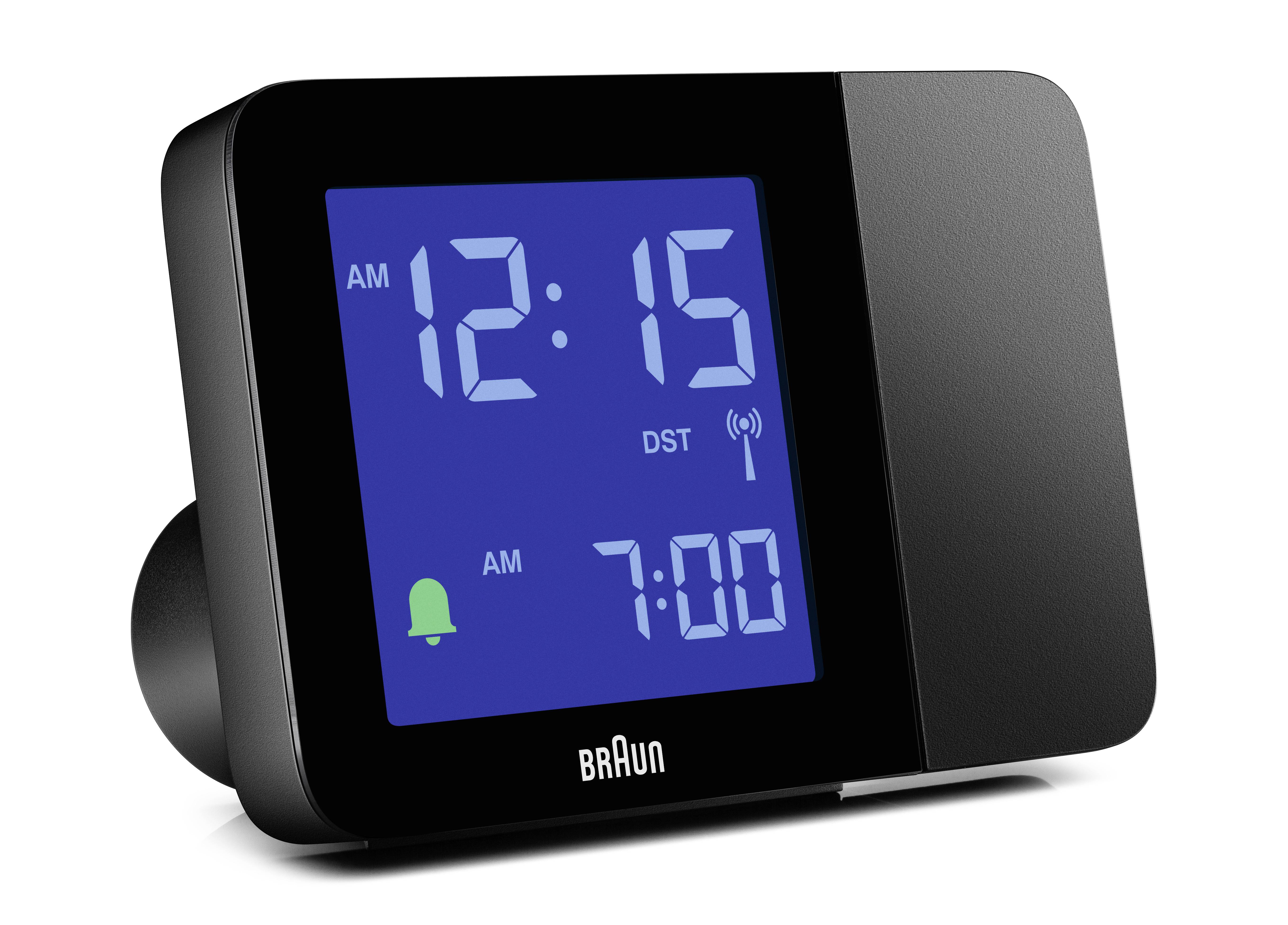 Black digital alarm clock with blue display. Shows '12:15 AM' and alarm time '7:00 AM'. A bell icon indicates the active alarm.
