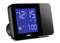 Black digital alarm clock with blue display. Shows '12:15 AM' and alarm time '7:00 AM'. A bell icon indicates the active alarm.