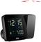 Digital alarm clock with large display showing '12:15 AM DST'. Alarm set to '7:00 AM'. Black casing with projection function.