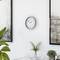 A bright, modern interior wall with a clock shows 11:54. Decorative plants and abstract paintings complement the minimalist design.