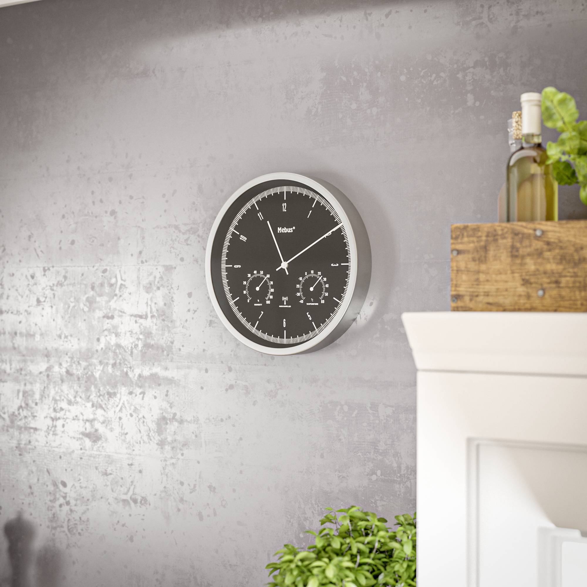 A black wall clock with white hands and numerals hangs on a grey wall. Beside it, a green plant sits on a cabinet.