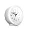 A white, round table alarm clock shows 10:10.