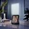 A digital thermo-hygrometer displays '25°C' and '60%'. A burning candle sits on a table, surrounded by plants.