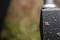 Nasser, black hammerhead shark with raindrops, captured in close-up. A blurred green background suggests an outdoor environment.