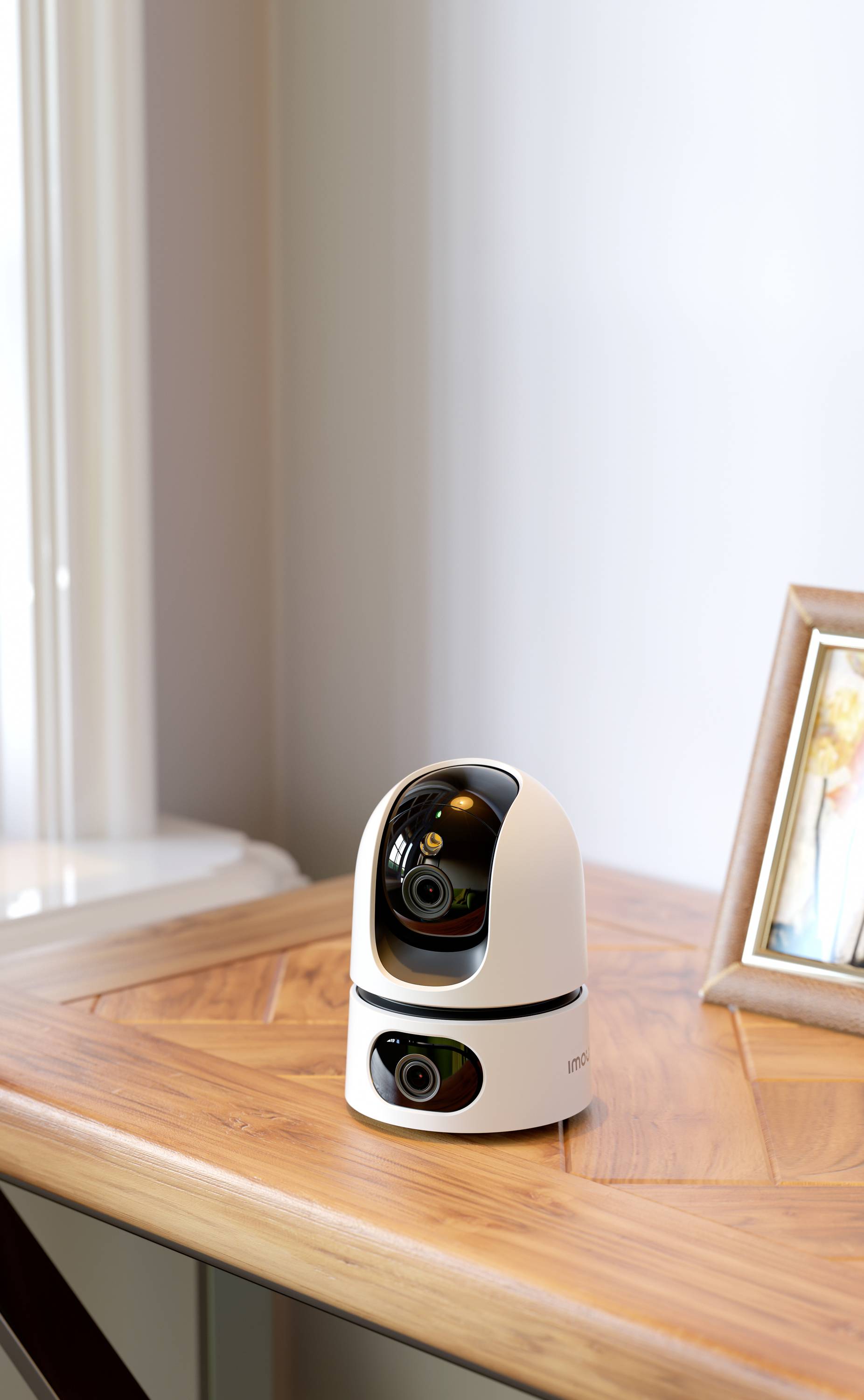 A surveillance camera on a wooden table, next to a framed photograph. The camera has a modern, circular design.