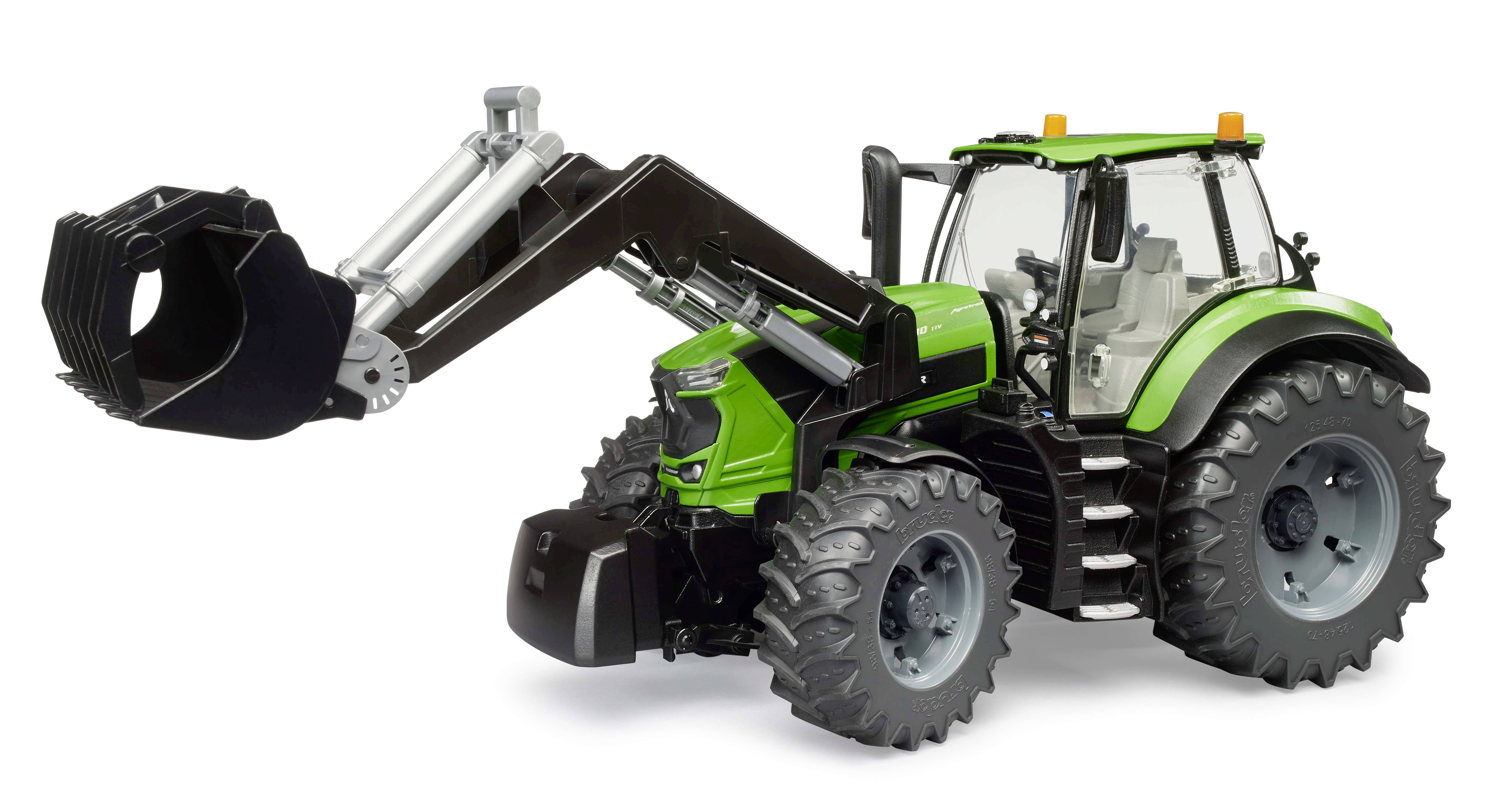 A green tractor with a front loader arm is lifting a black bucket. The tractor has large tyres and is suitable for agricultural work.