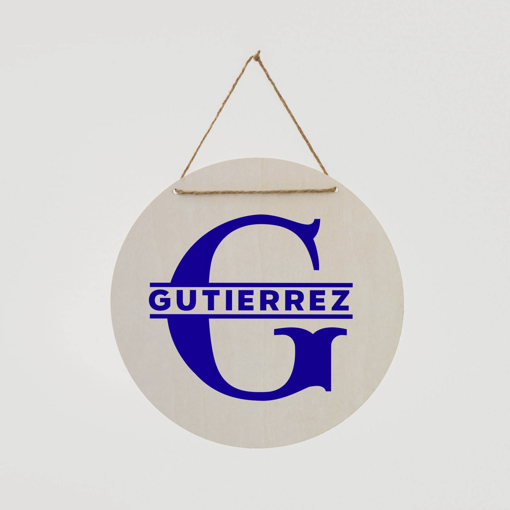 A round wooden sign hangs from a cord. Written in blue lettering is the name 'Gutierrez' beneath a large letter 'G'.
