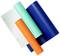Three rolls of vinyl film in blue, orange, and turquoise on a cutting mat with grid pattern, suitable for craft work and decorations.