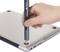 A hand is holding a screwdriver, which is being used to remove a screw from the underside of a laptop.