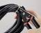 A hand is using pliers to secure a cable tie around a bundle of black cables.