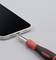'A smartphone is opened at the charging port with a small screwdriver.'